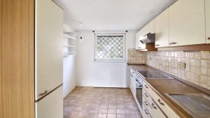 Küche mit angrenzender Garage und Zugang zum Keller